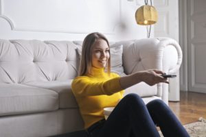 girl enjoying the Tv viewing with remote